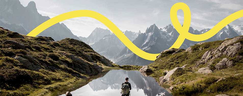 Mann steht auf Felsen vor Bergsee und Berglandschaft (Foto)