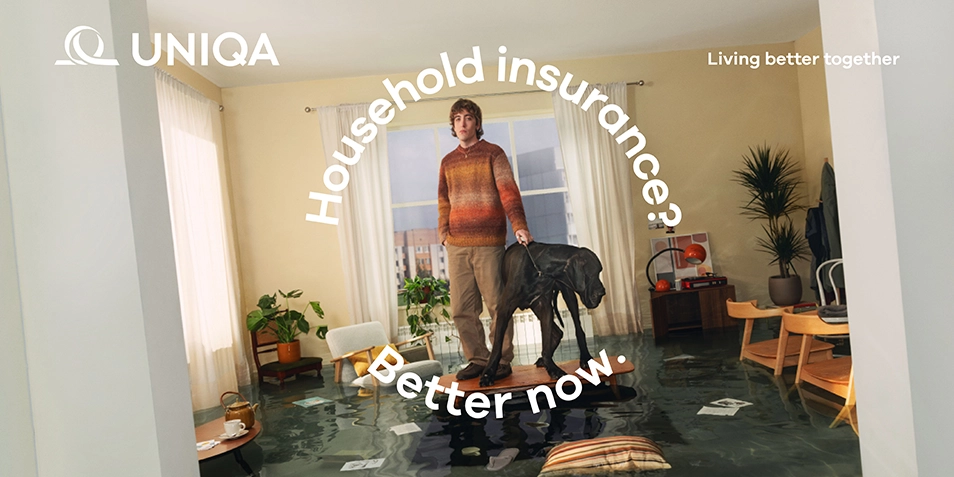 A new campaign showcases UNIQA’s new brand identity: a man with a dog standing on a table in a flooded apartment.
