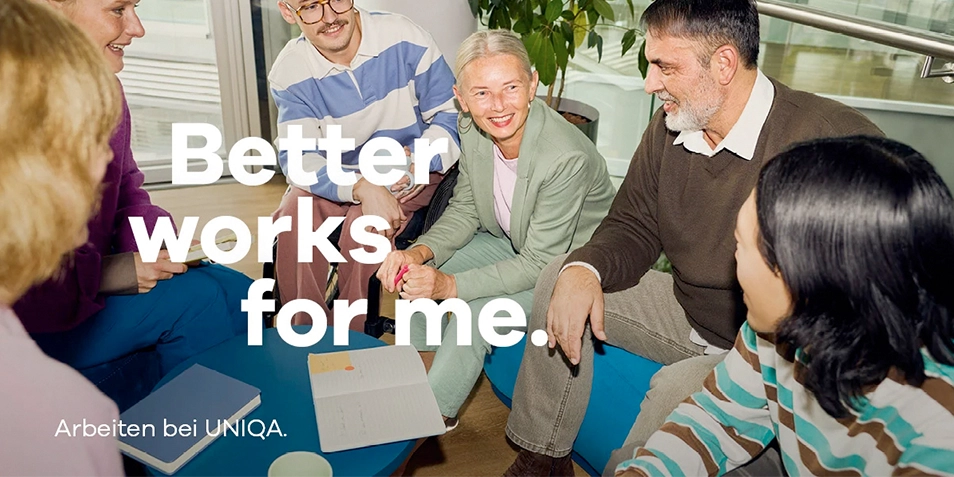 Neue Werbekampagne: Eine Gruppe von Menschen sitzt lächelnd in einem Bürosetting.