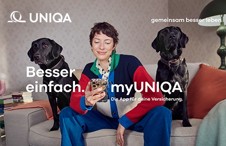 Neue Werbekampagne: Eine Frau sitzt mit zwei Hunden auf einem Sofa und hält ein Handy in der Hand.