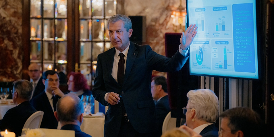 Kurt Svoboda präsentiert Grafiken bei einem Dinner-Event.
