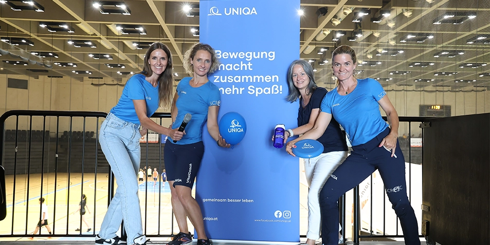 Vier Frauen in blauer Sportbekleidung in einer Sporthalle
